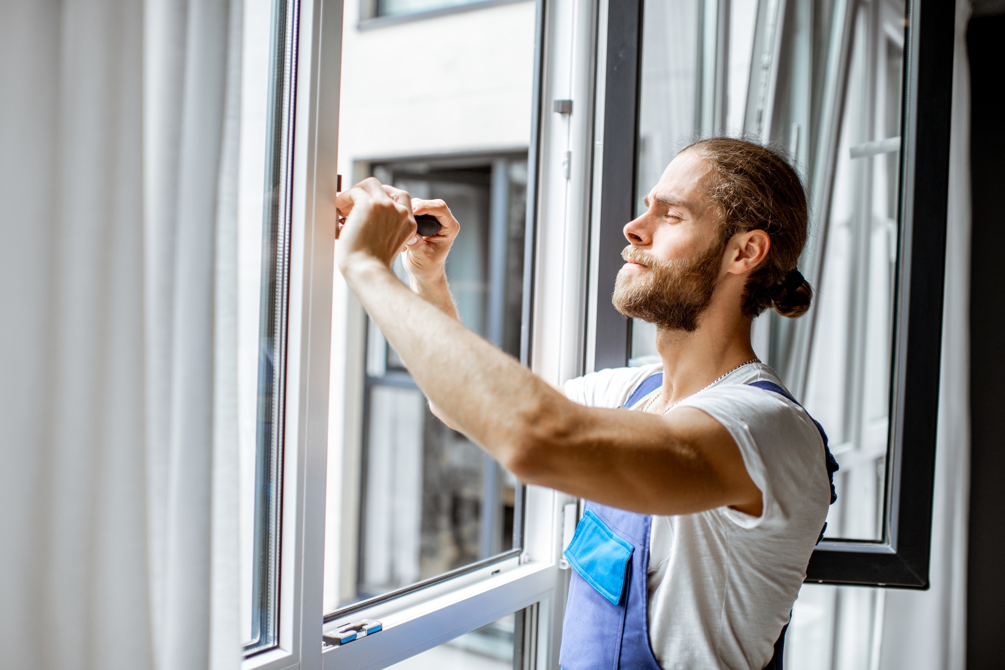 Workman adjusting window frames at home